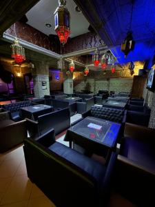 Una habitación con sillas y mesas negras y luces. en Hotel Mounia, en Fez