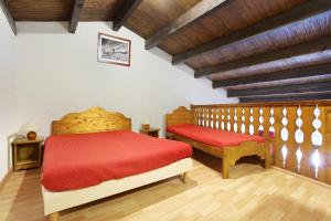 レ・キャローズ・ダラッシュにあるRésidence Odalys Le Front de Neigeのベッドルーム1室(赤いベッド1台、ベンチ2台付)