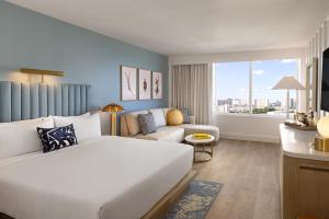 een hotelkamer met een groot bed en een bank bij The Sunny in Sunny Isles Beach +43 foto's