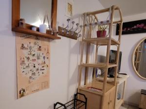 een kamer met een boekenplank en een plank met een plank bij À la campagne, studio 25m2-pour 2 au calme, wifi, jardin, parking in Yèvres