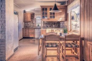 斯彻达尔Room Trondheim Airport的配有木制橱柜、桌子和椅子的厨房