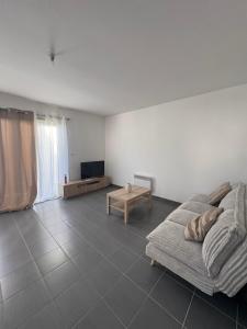 a living room with a couch and a table at Maison entière avec jardin , Proche Bordeaux, Rocade et Arkéa Arena in Bouliac