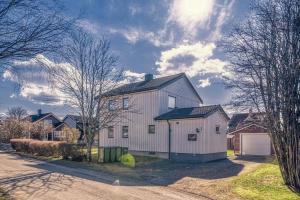 斯彻达尔Room Trondheim Airport的一座黑色屋顶的白色建筑