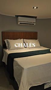 une chambre avec un lit portant l'inscription CHLAS dessus dans l'établissement Chalés Feliz Boipeba, à Cairu