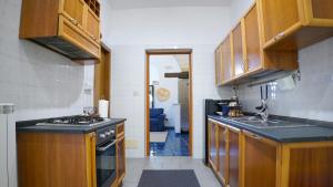 een keuken met houten kasten, een wastafel en een fornuis bij BlueBlu Apartment in Brindisi