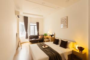 a bedroom with a bed and a living room at The Hammond Saigon in Ho Chi Minh City