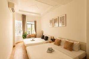 a living room with two beds and a couch at The Hammond Saigon in Ho Chi Minh City