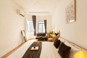 a living room with a bed and a couch at The Hammond Saigon in Ho Chi Minh City