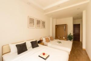 two beds in a hotel room with a tray on top at The Hammond Saigon in Ho Chi Minh City
