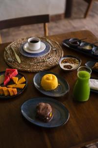 een houten tafel met borden met eten erop bij Beijo do Vento Pousada in Arraial d'Ajuda