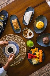 een houten tafel met borden met eten erop bij Beijo do Vento Pousada in Arraial d'Ajuda