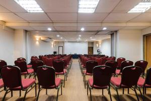 an empty room with red chairs and a screen at Vitoria Praia Hotel in Vitória