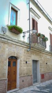 een gebouw met 2 balkons en een houten deur bij BlueBlu Apartment in Brindisi