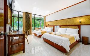 a hotel room with two beds and a desk and a desk at El Nido Viewdeck Cottages in El Nido