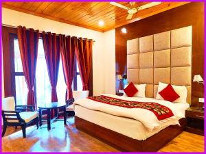 una camera da letto con un letto grande, un tavolo e delle sedie di Hotel Saanidhya Blue Moon Palace Inn Near Bhimtal Lake- Wifi - Room Service - Parking Facilities - Velly view Hotel a Nainital