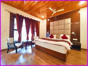 una camera da letto con un letto, una scrivania e una finestra di Hotel Saanidhya Blue Moon Palace Inn Near Bhimtal Lake- Wifi - Room Service - Parking Facilities - Velly view Hotel a Nainital Altre 14 foto