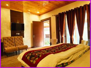 una camera da letto con un letto, una tv e una finestra di Hotel Saanidhya Blue Moon Palace Inn Near Bhimtal Lake- Wifi - Room Service - Parking Facilities - Velly view Hotel a Nainital