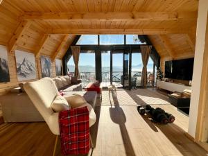 a living room filled with furniture and a large window at Vikendica Nomadova Koliba in Tvrdimići