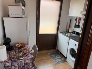 a small kitchen with a refrigerator and a sink at Estudio de encanto en Isla playa in Arnuero