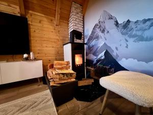 a room with a fireplace with a mountain mural on the wall at Vikendica Nomadova Koliba in Tvrdimići