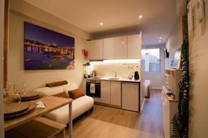 a kitchen and living room with a couch and a table at Feel Porto in Bolhão "Metro at your doorstep" in Porto