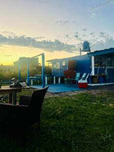 een huis met een tafel en stoelen in het gras bij El Antiguo Hostel in Cabo Polonio