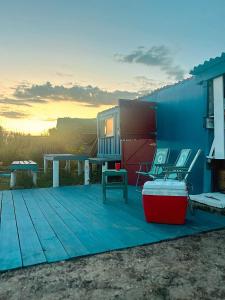 een huis met een terras met stoelen en een tafel bij El Antiguo Hostel in Cabo Polonio