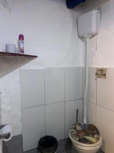 een witte badkamer met een toilet in een kamer bij El Antiguo Hostel in Cabo Polonio +6 foto's
