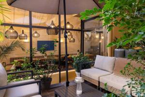 a patio with a couch and a table with plants at Crisol Lumière in Cannes