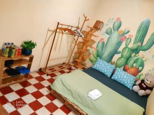een slaapkamer met een bed met een cactus muurschildering aan de muur bij Homestay GÁC MƠ Vũng Tàu in Vung Tau