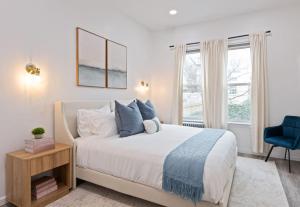 a bedroom with a bed and a blue chair at The Harper Loft near Manhattan with NYC skyline view in Hoboken +79 photos