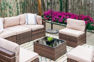 a patio with wicker chairs and a table and flowers at The Harper Loft near Manhattan with NYC skyline view in Hoboken