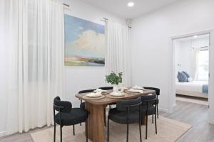 a dining room with a table and black chairs at The Harper Loft near Manhattan with NYC skyline view in Hoboken
