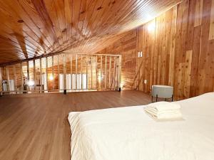 een grote kamer met een bed en houten wanden bij Duplex Chalet style private yard 150m to RER in Bagneux +12 foto's