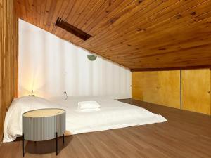 een slaapkamer met een wit bed en een houten plafond bij Duplex Chalet style private yard 150m to RER in Bagneux