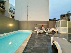 una piscina con sedie a sdraio e una piscina di Central Oasis with Private Pool and Lounge Area a Msida