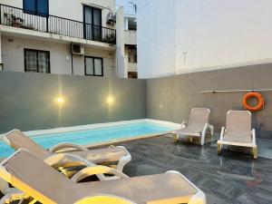 una piscina con sedie a sdraio e una piscina di Central Oasis with Private Pool and Lounge Area a Msida
