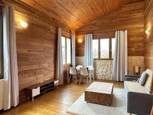 een woonkamer met houten wanden en een tafel en stoelen bij Duplex Chalet style private yard 150m to RER in Bagneux