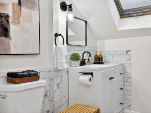 a white bathroom with a sink and a toilet at The Harvard Loft with Game Room and Free Parking Near Harvard Square in Cambridge +88 photos