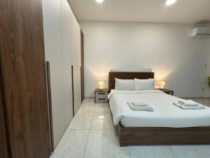 una camera da letto con un letto grande con due asciugamani sopra di Central Oasis with Private Pool and Lounge Area a Msida Altre 26 foto