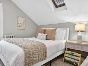a bedroom with a large white bed and a table at The Harvard Loft with Game Room and Free Parking Near Harvard Square in Cambridge