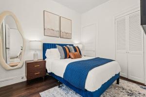 a bedroom with a blue and white bed and a mirror at The Caleb Loft near Manhattan with NYC skyline view in Hoboken