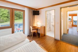 een hotelkamer met een bed en een bureau en een kamer bij Ski-In/Ski-Out Hotel Sport in Saas-Almagell