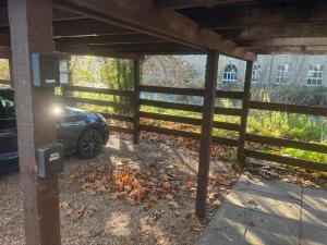 een auto geparkeerd onder een hek met bladeren op de grond bij Canal Side Retreat in Heybridge +29 foto's