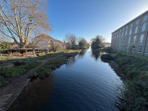 een rivier in een stad met een gebouw ernaast bij Canal Side Retreat in Heybridge