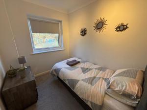 a bedroom with a bed and two mirrors on the wall at Canal Side Retreat in Maldon +29 photos