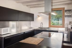 a kitchen with a sink and a microwave at Ca Bosca - Fine Living in Torri del Benaco