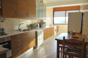 a kitchen with a sink and a refrigerator and a table at Apartment with 2 bedrooms in Infantado in Loures in Loures +14 photos