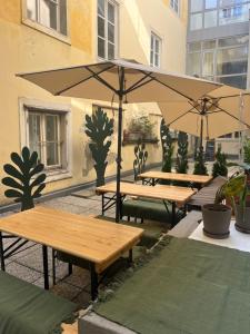 twee picknicktafels met parasols voor een gebouw bij Sishaus Hostel in Graz