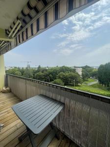 a bench on a balcony with a view of trees at Chambre meublé Lormont in Lormont